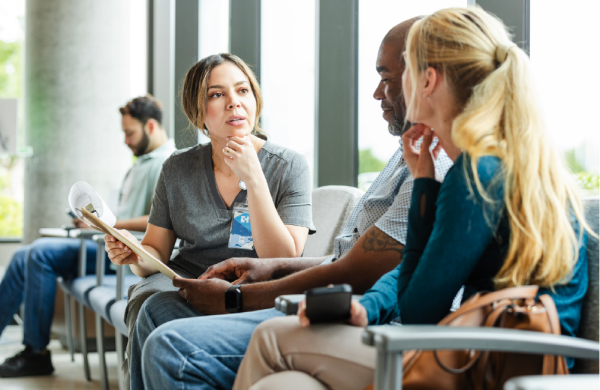 doctor sitting with male patient and female partner to go over bill