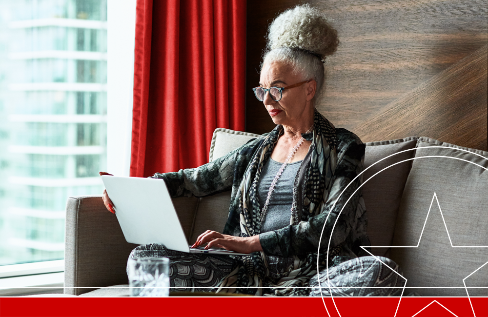Woman in her 60s sitting on sofa using laptop, connection, communication, remote working