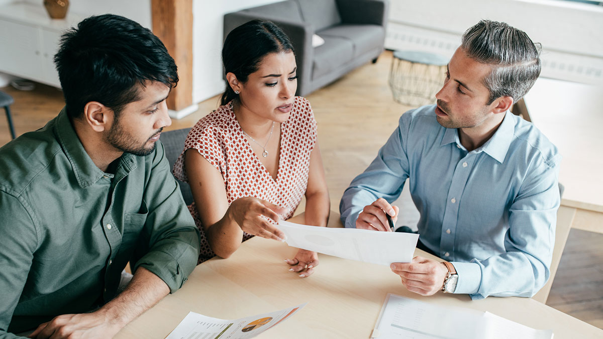 three people sitting at a table talking