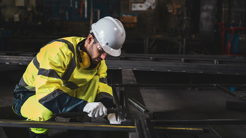 mechanic measuring at a metal factory