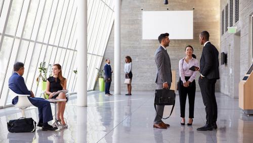 Colleagues talking in an office lobby