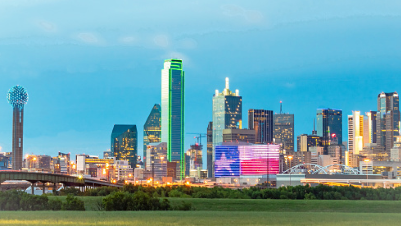 Dallas skyline with the omni hotel showcasing the Texas flag