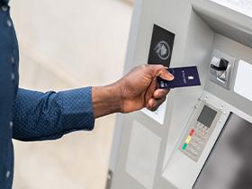 Hand inserting an access key card into an electronic door lock on a wall