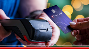 person tapping texas capital debit card on card reader payment system